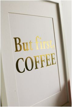 a framed print with the words but first, coffee in gold foil on white paper