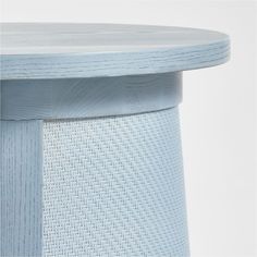 an up close view of the top of a blue stool with wicker pattern on it