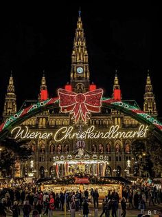 people are standing in front of an illuminated christmas market