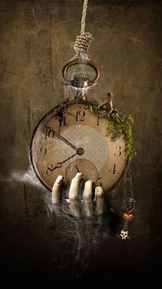 a hand holding an old clock with moss growing out of it's face and hanging from a rope