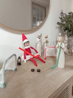 the elf is playing with his toys on the table in front of the mirror and other decorations