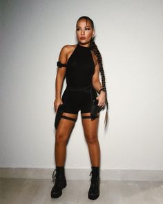 a woman in short shorts and boots posing for the camera with her hair pulled back