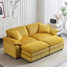 a living room with yellow couches and pictures on the wall