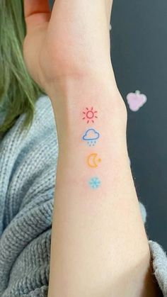 a woman's arm with the sun, moon and stars tattoo on her left wrist