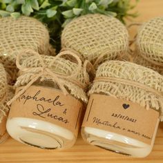 several jars with labels on them sitting next to a plant and some burlocks