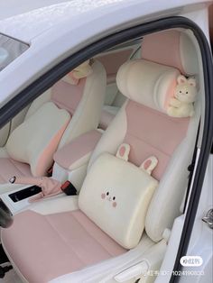 the interior of a white car with pink seats and stuffed animals on it's headrests