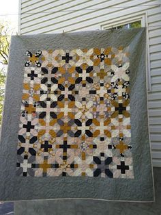 a quilt hanging from the side of a house