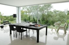 a dining room table and chairs in front of large windows