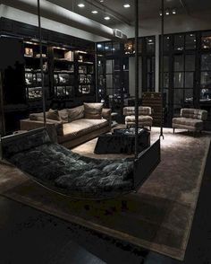 a living room filled with furniture and lots of windows in the dark night time sky