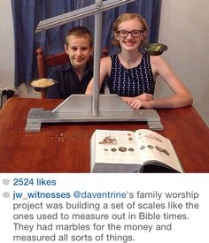 two children sitting at a table with an open book