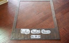 a wooden frame with the names of two bride and grooms on it in front of a wood floor