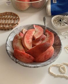 a plate full of sliced peaches on a table next to some other fruit items