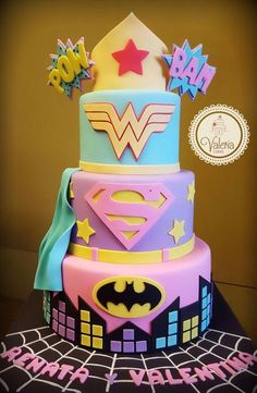 a multi - tiered cake decorated with fondant, stars, and superman logos