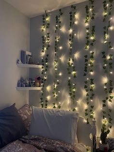 a bed room with a neatly made bed and lots of lights on the wall behind it