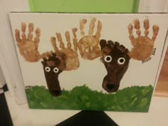 two hand prints made to look like deers with eyes and hands on them are shown in front of a green background