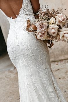 a woman in a wedding dress holding a bouquet of flowers