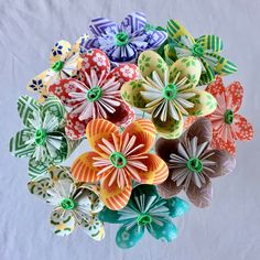 an arrangement of colorful paper flowers in a vase