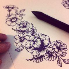 someone is drawing flowers on paper with a pen and inking it onto the page