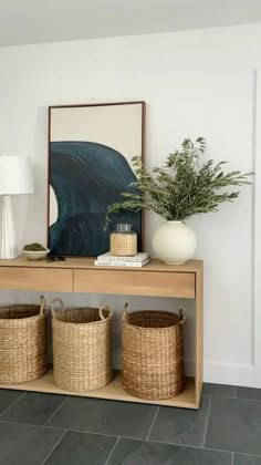 a person holding a wicker basket in front of a wooden cabinet on the floor