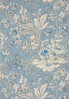 a blue and white floral wallpaper with lots of green flowers on the bottom half of it