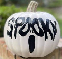 a white pumpkin with black lettering on it