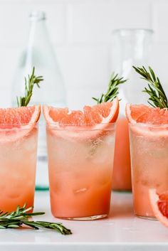 three glasses filled with watermelon and rosemary garnish