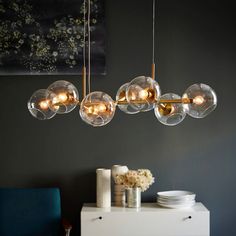 a modern chandelier hanging over a dining room table