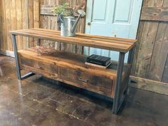 a wooden table with two drawers and a metal watering can on it's top