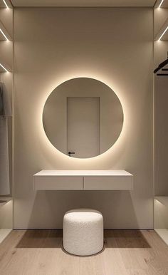 a bathroom with a round mirror and lights on the wall, along with a stool