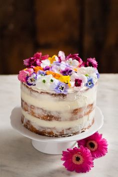 a cake with white frosting and colorful flowers on top