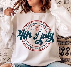 a woman sitting on a couch wearing a white shirt with the words, freedom fireworks