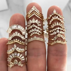 a person holding five different types of rings in their hand, all with diamonds on them