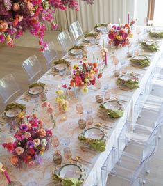 a long table is set with flowers and plates