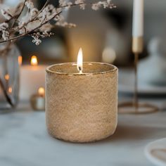 a lit candle sitting on top of a table