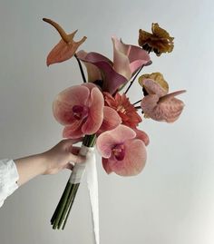 a person holding a bouquet of flowers in their hand