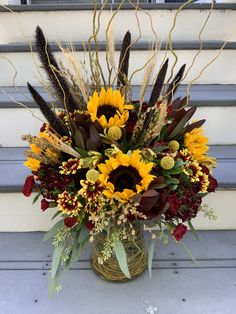 a vase filled with sunflowers and other flowers