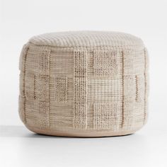 a white ottoman that is made out of woven material