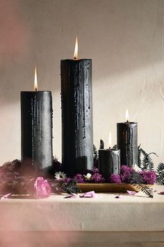 three black candles sitting on top of a table