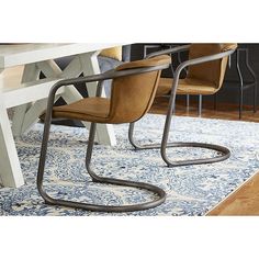 two chairs sitting on top of a blue rug next to a white dining room table