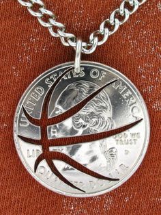 a basketball necklace with a silver ball on the front and red back ground, hanging from a metal chain