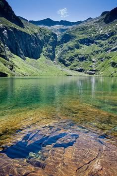 the water is crystal green and clear in this mountain lake, surrounded by rocky mountains