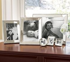 three framed photos are sitting on a dresser next to a vase with flowers in it