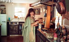 a woman standing in a kitchen next to an oven