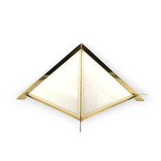 a gold and black triangle shaped object on a white background