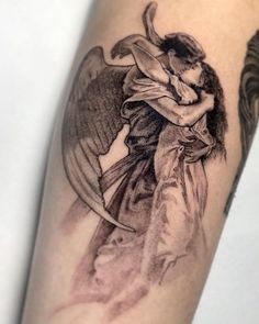 an angel tattoo on the arm with a woman holding a baby in her arms and wings