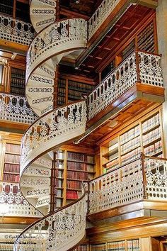 a spiral staircase in a library with bookshelves