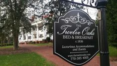 a black and white sign that reads the trecele club bed & breakfast in front of a large house