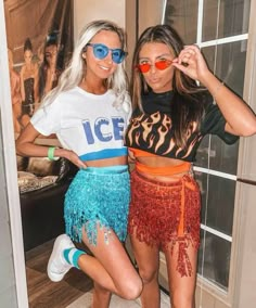 two women posing for the camera in front of a window