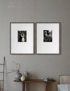 two framed photographs hang on the wall above a table