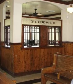 the inside of a restaurant with wooden tables and benches in front of windows that read tickett's